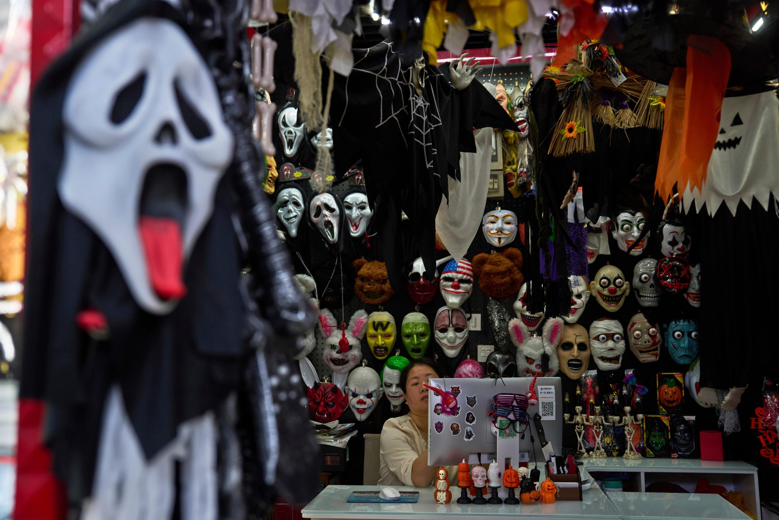 A vendor of halloween costumes wait for customers at the...