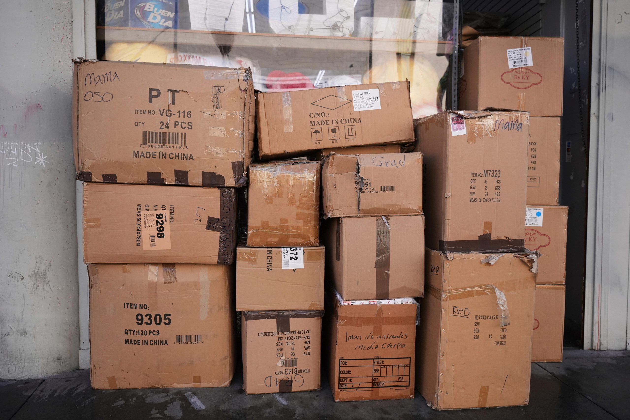 Boxes of party supplies imported from China are stacked outside...